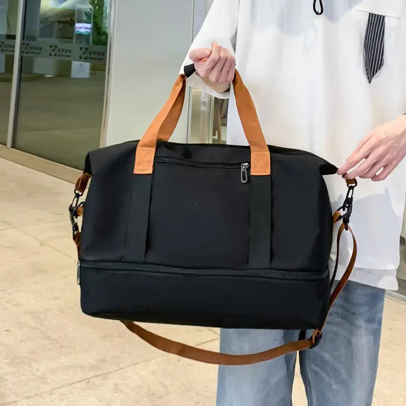 The Packt Weekender duffel in Black carried by the top handles